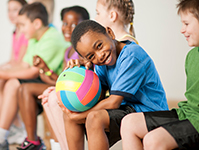 Student holding volleyball in gym class